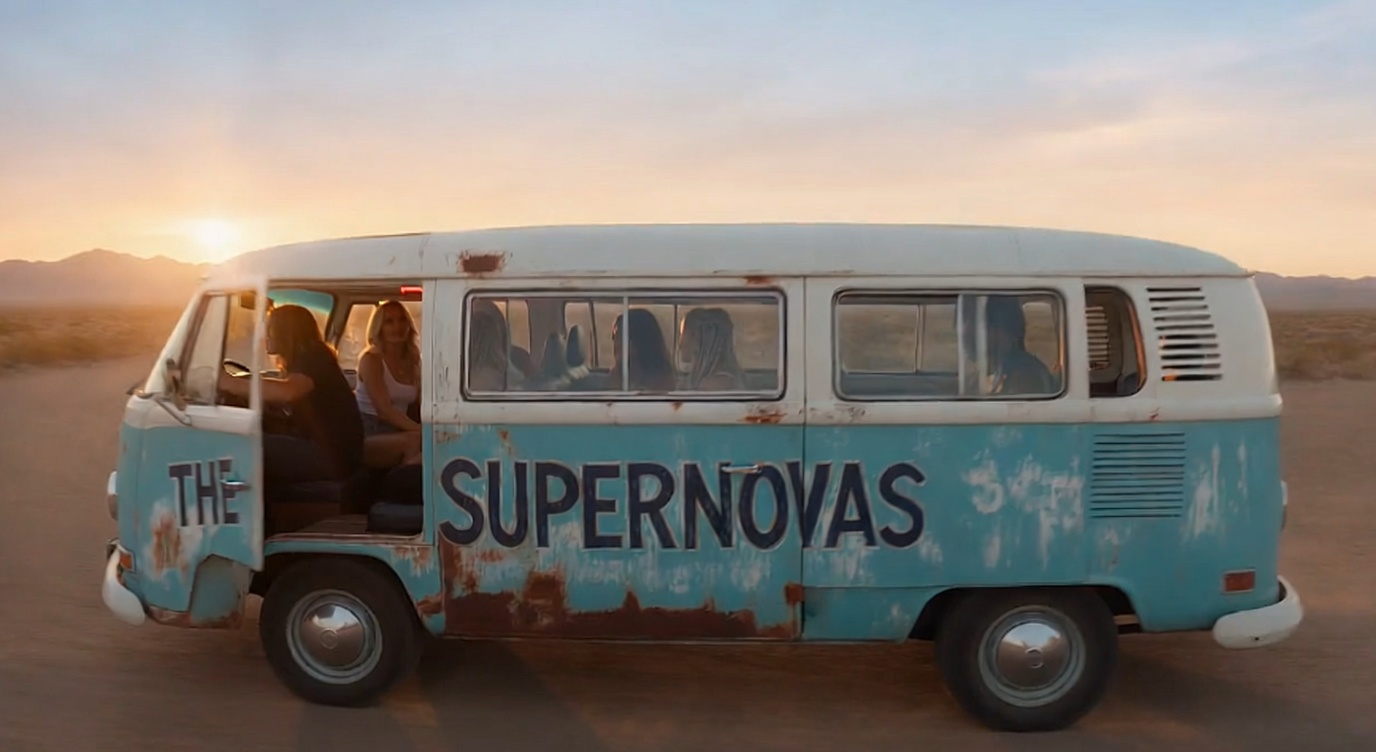 The Supernovas together inside their vintage tour bus in the New Mexico desert at sunset